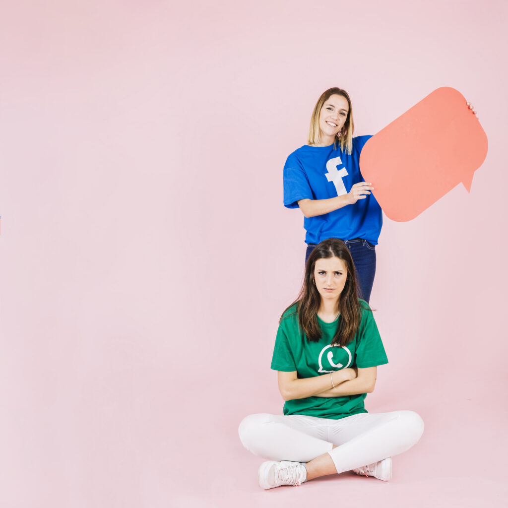 upset woman sitting front her happy friend holding speech bubble Social Media Marketing